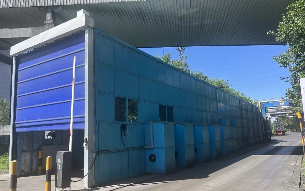 Fully enclosed drive-through heavy duty truck wash system at an industrial site